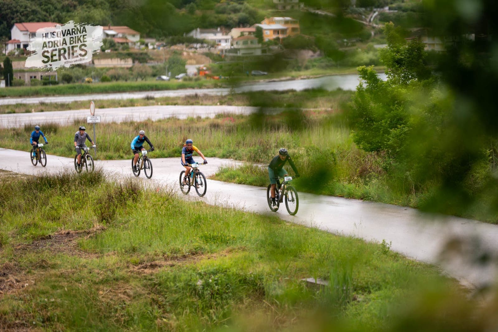 Small group of riders climbing a wet road during Rab MTB Marathon 2026.