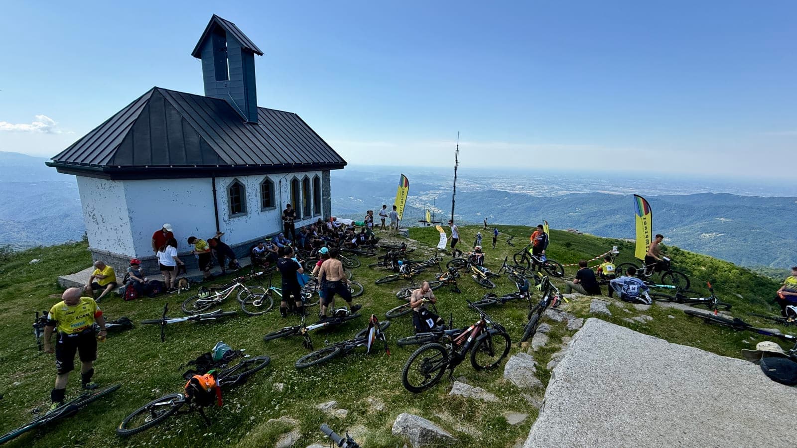 Riders and bikes gathered near the chapel on Mount Matajur before an enduro stage.
