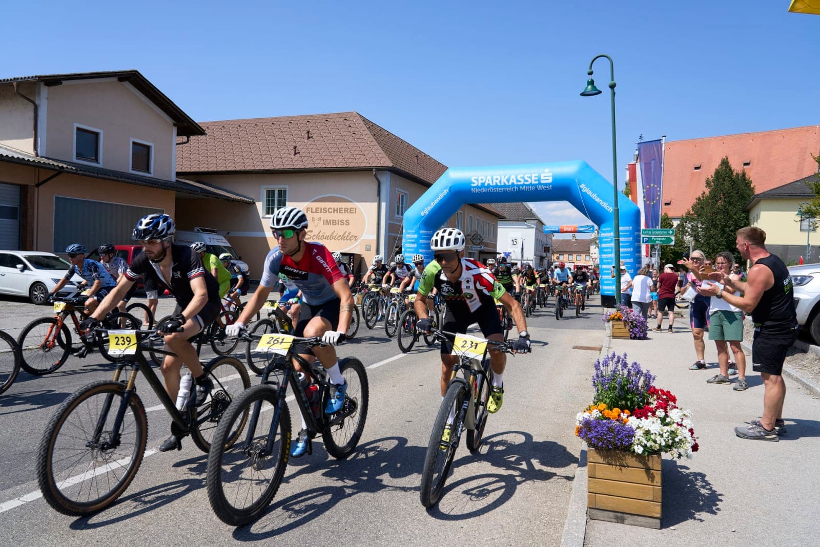 Riders rolling out beneath the Mostviertler Bike Marathon 2026 start arch in Mank.